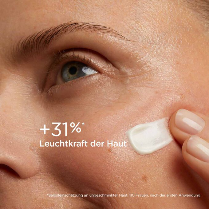 Frau mit geschlossenen Augen, die SOS Primer White von Clarins auf dem Gesicht trägt, um zu verdeutlichen, dass er Zeichen von Müdigkeit um 20 % mindert.
