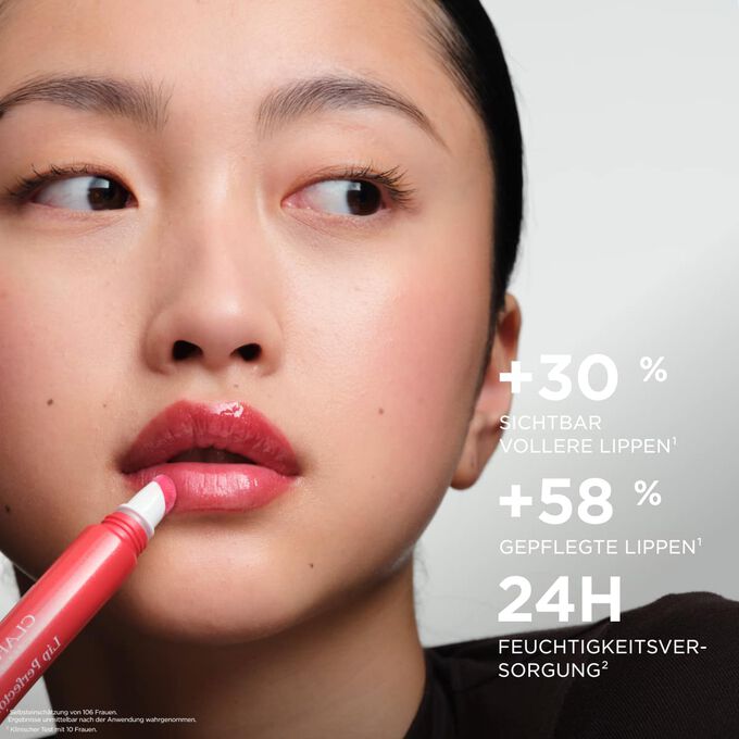 Eine Frau beim Auftragen des Clarins Plumping Lip Perfectors &ndash; f&uuml;r sichtbar vollere, gepflegte Lippen und 24H-Feuchtigkeitswirkung