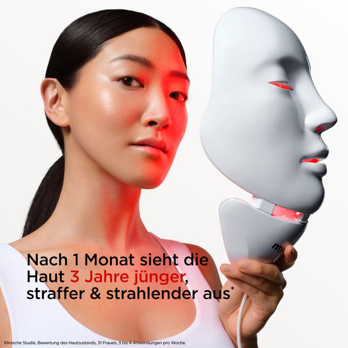 Nahaufnahme eines Models, das die myLEDmask2 f&uuml;r Gesicht und Hals in der Hand h&auml;lt, wobei deren Vorteile hervorgehoben werden, die Haut j&uuml;nger, straffer und strahlender wirken zu lassen