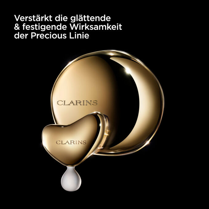 Foto des Clarins Precious Massagetools vor einem dunklen Hintergrund mit Text, der seinen Nutzen für die Precious Linie betont.