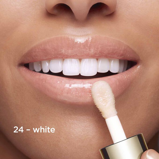 Close-up lächelnder Lippen, auf die die Textur und Farbe des weißen Lippen-Öls zeigen, das auf den pH-Wert der Lippen reagiert hat