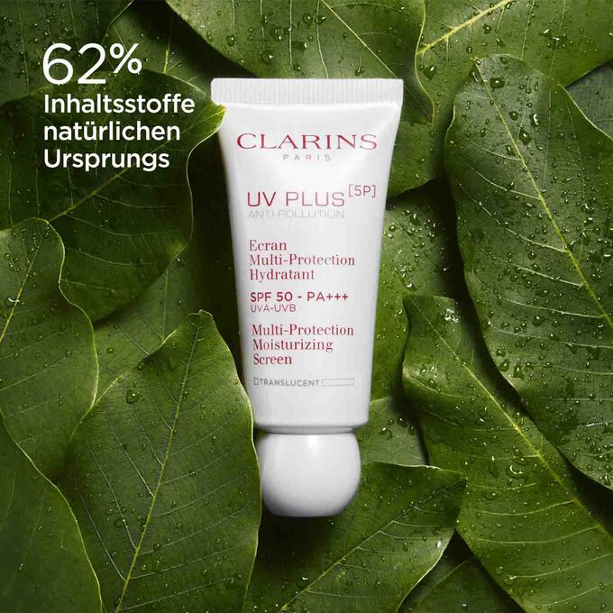Packshot von Clarins UV Plus Anti-Pollution Translucent, umgeben von Bio-Mangoblättern, um den Anteil von 62 % natürlichen Inhaltsstoffen zu betonen.