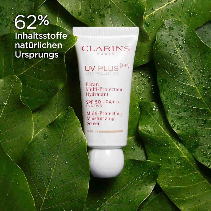 Packshot von Clarins UV Plus Anti-Pollution Beige, umgeben von Bio-Mangoblättern, um den Anteil von 62 % natürlichen Inhaltsstoffen zu betonen.