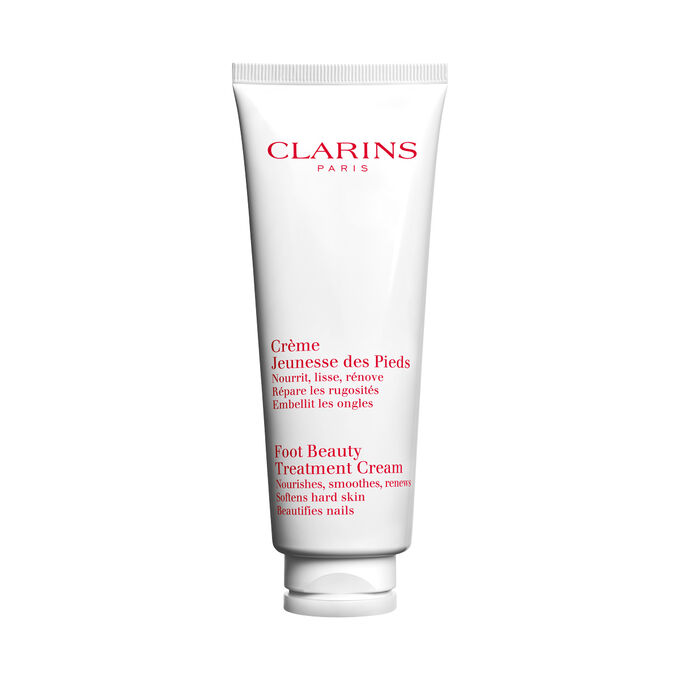 Plan produit d'un tube de Cr&egrave;me Jeunesse des Pieds Clarins avec des noix de karit&eacute; sur fond blanc.