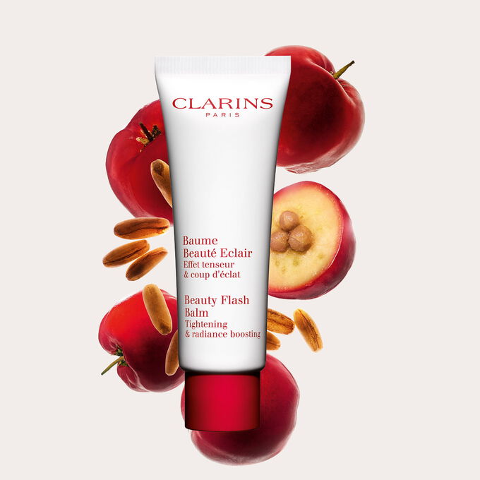 Plan produit d'un tube de Baume Beaut&eacute; &Eacute;clair Clarins avec des baies d'ac&eacute;rola sur fond p&ecirc;che.