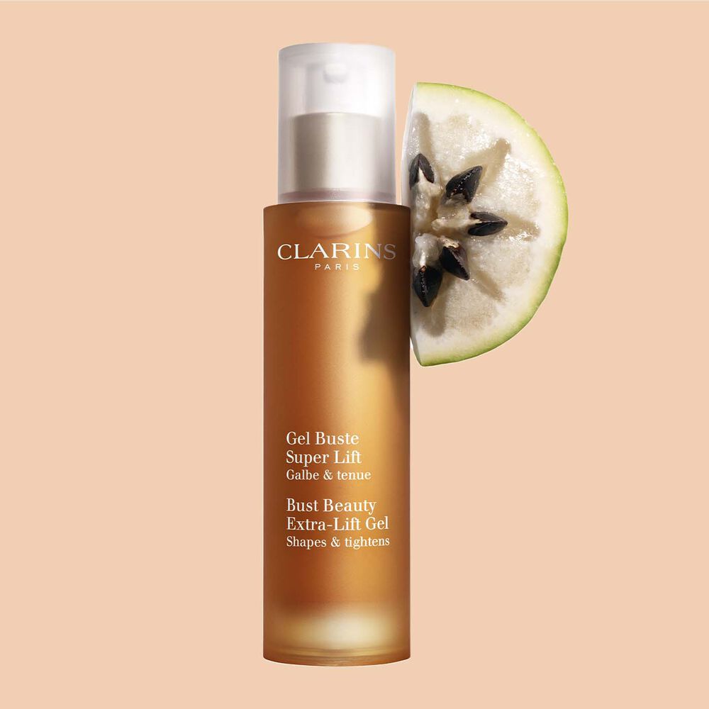 Packshot einer Flasche Clarins Gel Buste Super Lift mit einer Scheibe Vu-sua-Frucht vor einem pfirsichfarbenen Hintergrund.