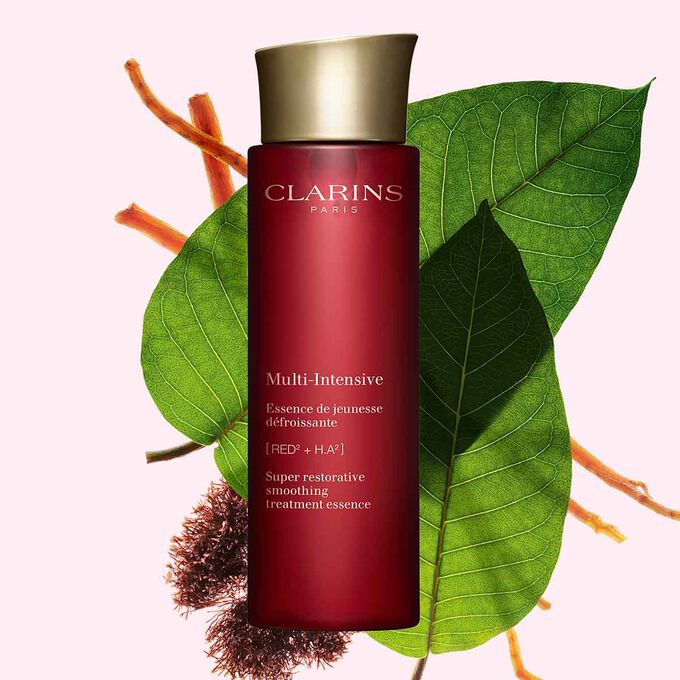 Packshot von Clarins Multi-Intensive Gesichtspflege-Essenz mit Roter Janie, Haronga-Blättern und Ginsengwurzel vor rosa Hintergrund.