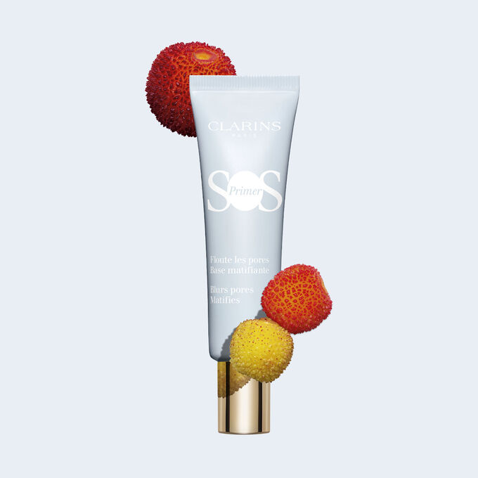 Packshot einer Tube SOS Primer Matifying von Clarins mit Erdbeeren und anderen Früchten, um Poren zu kaschieren und Glanz zu mindern.