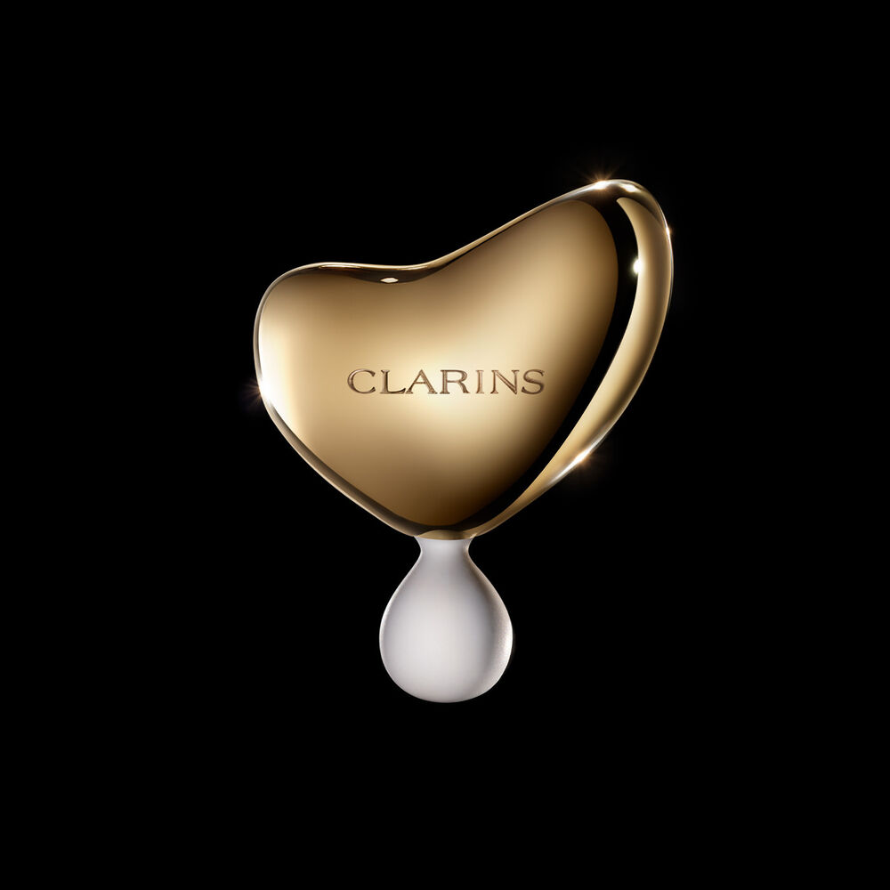Photo de L’Outil de Massage Clarins Precious sur fond noir.