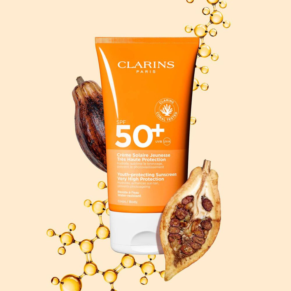 Photo de la Crème Solaire Jeunesse Très Haute Protection SPF 50 Clarins pour le corps, parmi des molécules de collagène et des fèves de cacao.