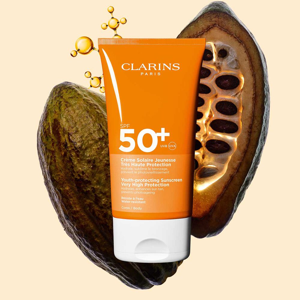 Photo de la Crème Solaire Jeunesse Très Haute Protection SPF 50 Clarins pour le corps, parmi des molécules de collagène et des fèves de cacao.