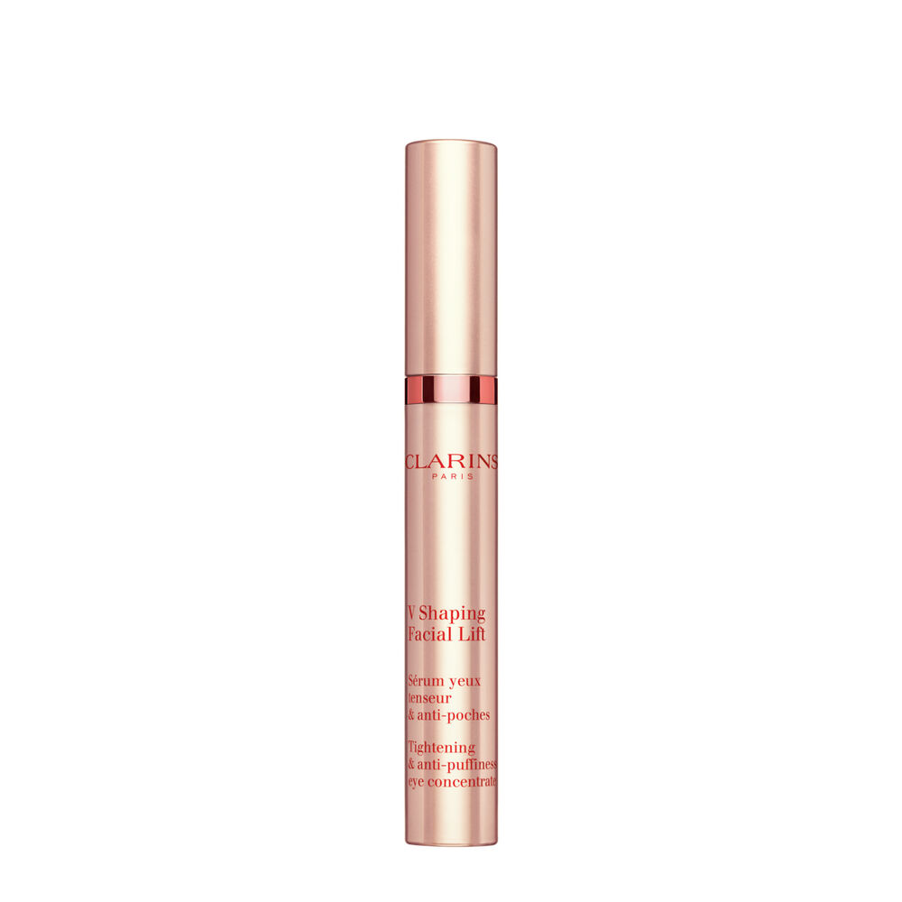 Plan produit d'un tube de V Shaping Facial Lift Yeux de Clarins avec de la mousse irlandaise sur fond rose clair.