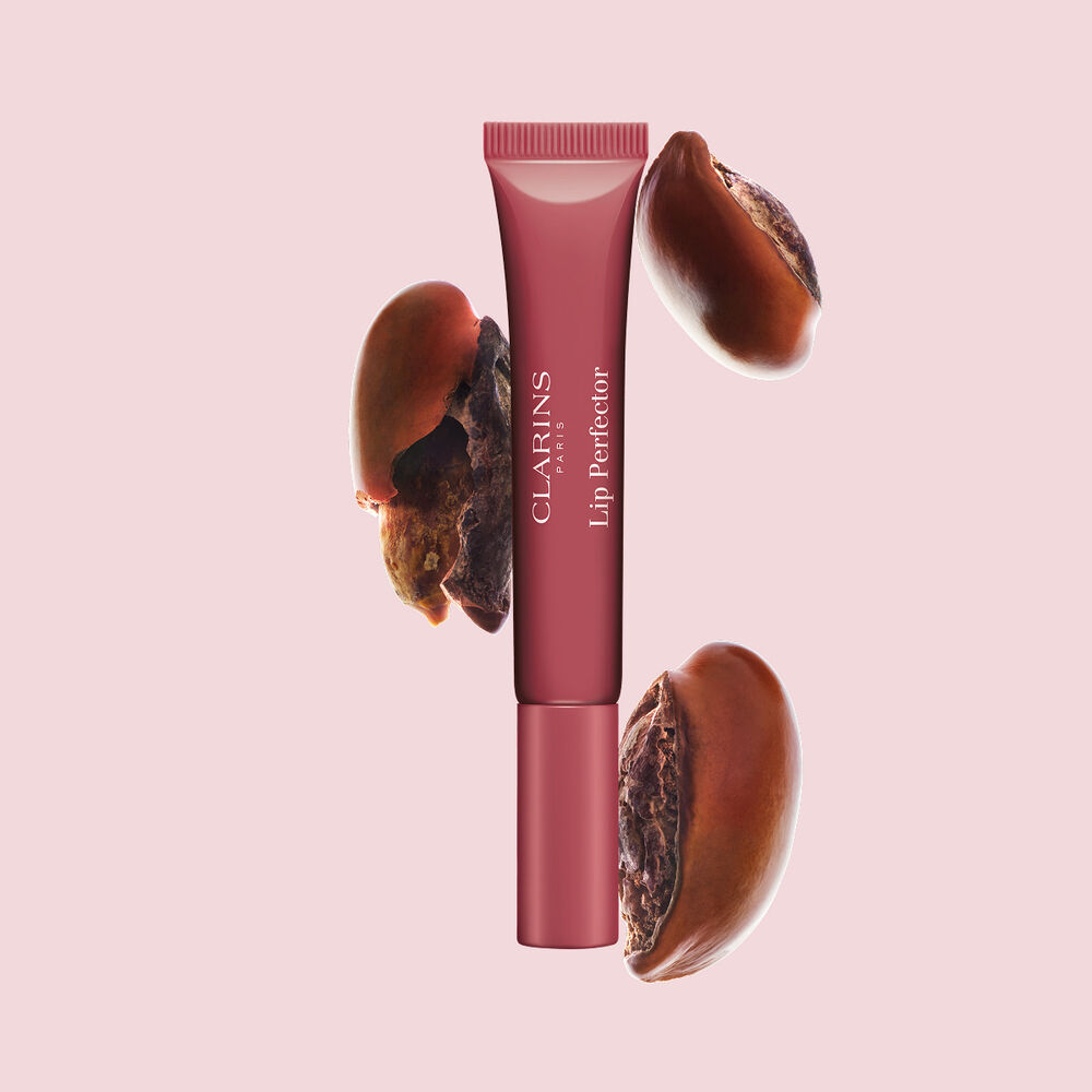 Tube des Clarins Plumping Lip Perfectors mit rohen Sheasamen &ndash; zur Hervorhebung der intensiven Pflegeformel f&uuml;r tiefenwirksame N&auml;hrung