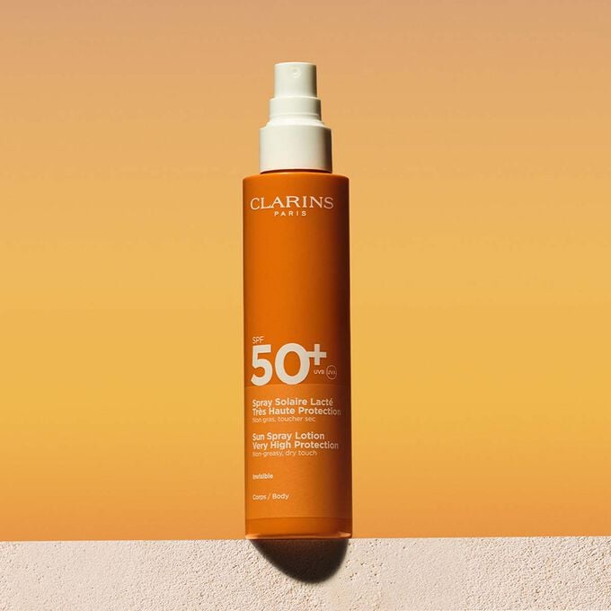 Plan produit d'une lotion solaire corps SPF50 en spray accompagn&eacute;e d'un message annon&ccedil;ant que Clarins s'engage en faveur de la protection de l'environnement