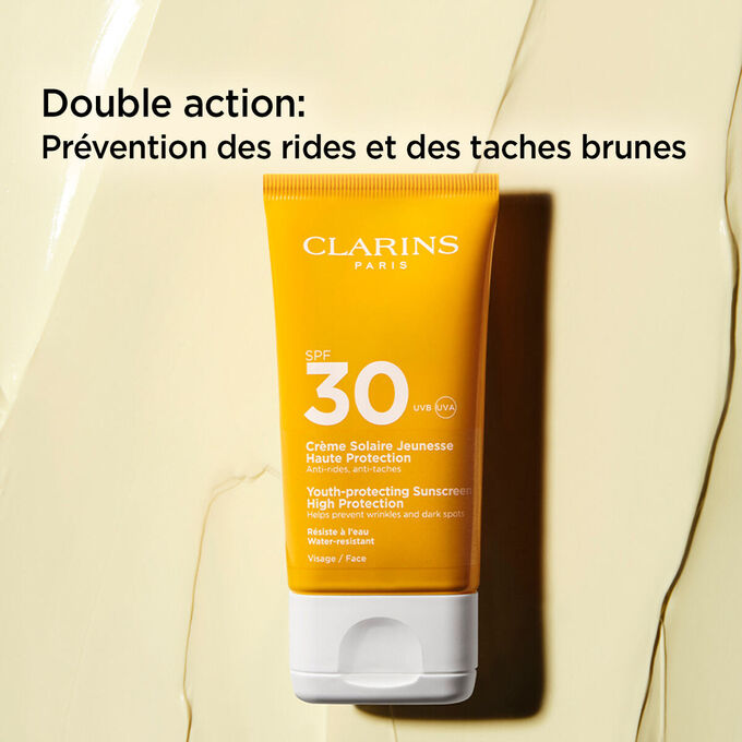 Plan produit sur fond textur&eacute; d&rsquo;un tube de cr&egrave;me anti-&acirc;ge&nbsp;SPF30+ avec un texte expliquant d&eacute;crivant ses actions antirides et antitaches