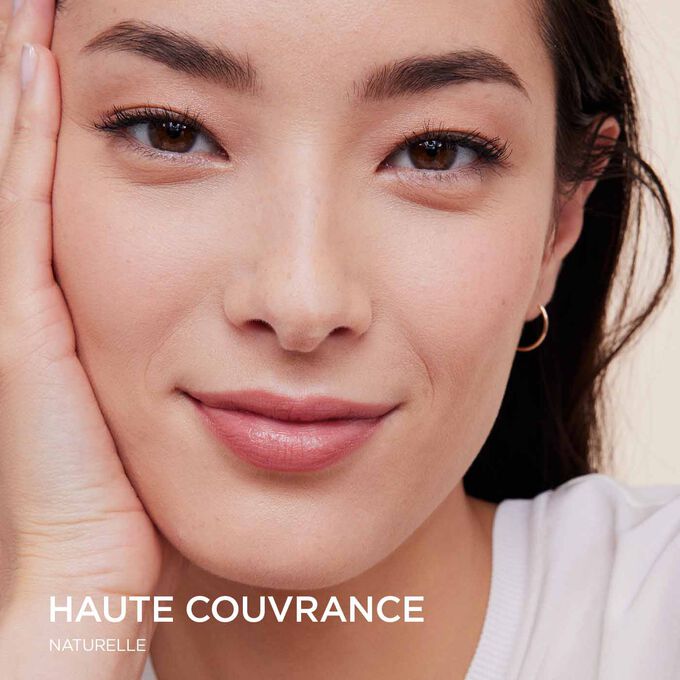 Femme portant le fond de teint Skin Illusion Couvrance Totale de Clarins offrant une couvrance totale et un résultat naturel.