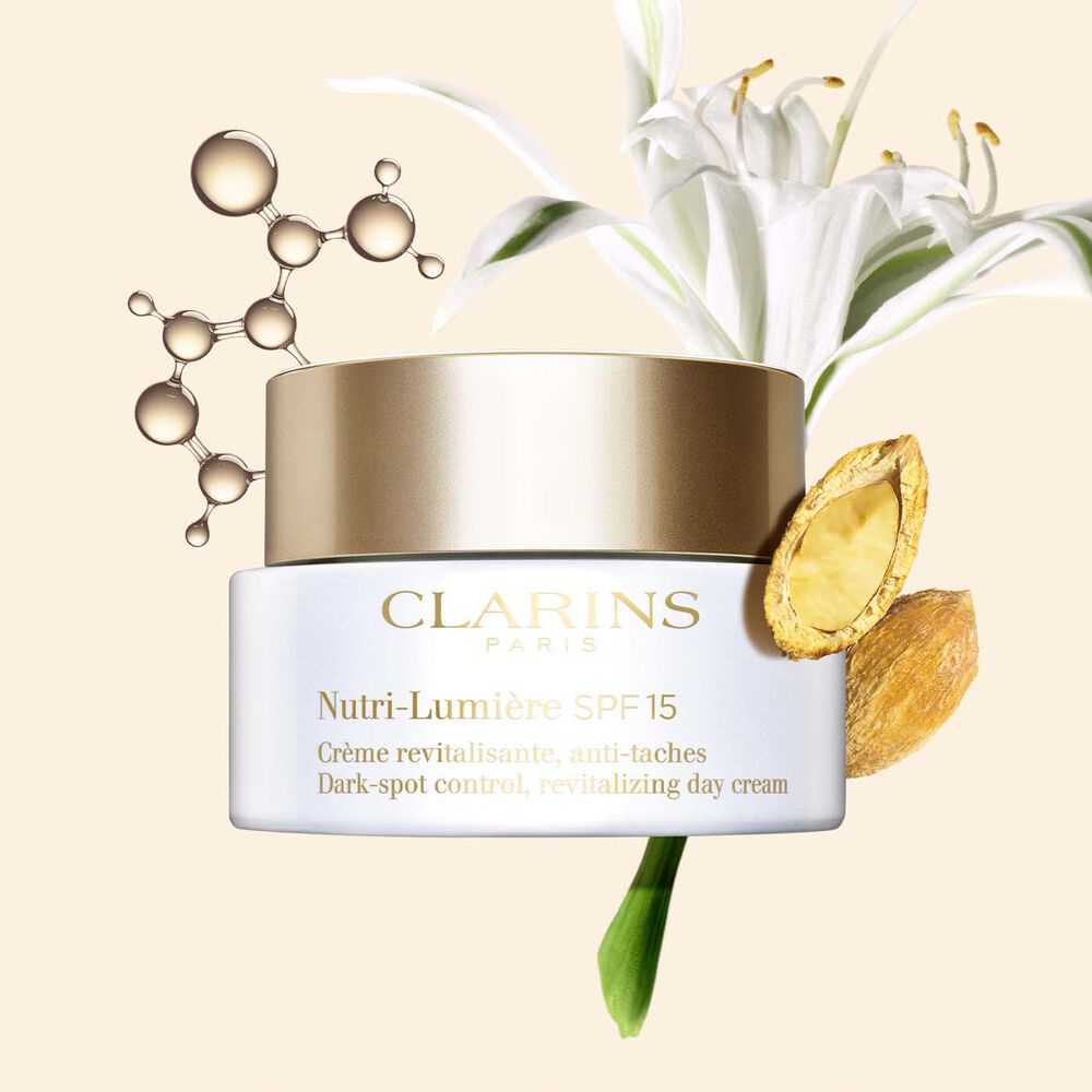Plan produit de la crème anti-imperfections Nutri-Lumière SPF15 avec des molécules de niacinamide, un lys de mer et une datte du désert.