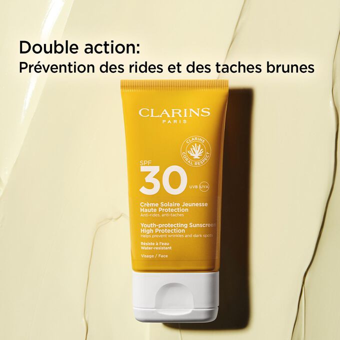 Plan produit sur fond texturé d’un tube de crème anti-âge SPF30+ avec un texte expliquant décrivant ses actions antirides et antitaches