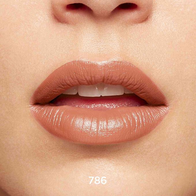 Gros plan sur des lèvres souriantes pour montrer la texture et la couleur de la teinte beige du rouge à lèvres Joli Rouge sur la carnation