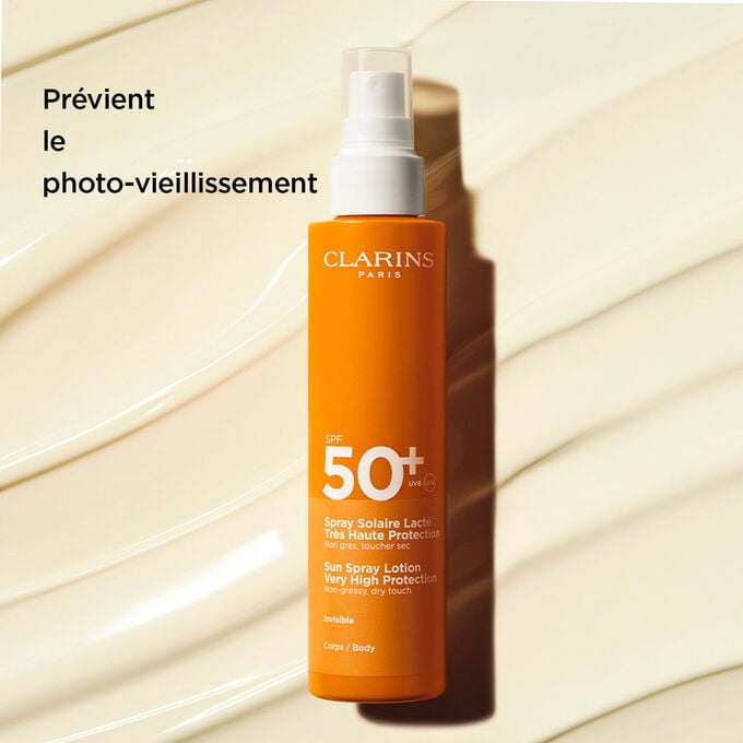 Plan produit sur fond textur&eacute; du lait solaire corps en spray 50+ avec du texte sur ses effets pr&eacute;venant le photo-vieillissement