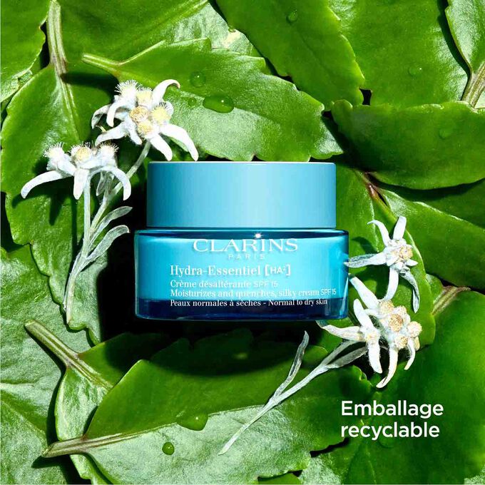 Plan produit crème Hydra-Essentiel SPF15 parmi des feuilles et fleurs d'edelweiss, avec un texte sur l'emballage recyclable.