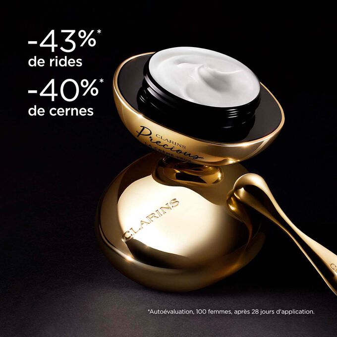 La Crème Yeux Clarins Precious sur fond noir, avec texte expliquant son pouvoir pour une peau 5 ans plus jeune
