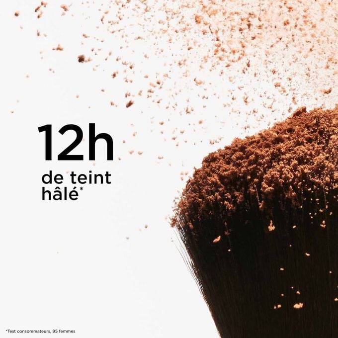 Zoom sur la pointe d'un pinceau &agrave; poudre saupoudr&eacute; de poudre bronzante, illustrant son effet &laquo; h&acirc;l&eacute; naturel &raquo; qui dure 12 heures pour un fini &eacute;clatant.