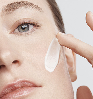 Model beim Auftragen der Creme