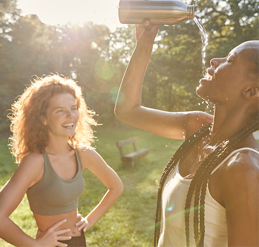 2 junge Frauen trinken Wasser und lachen